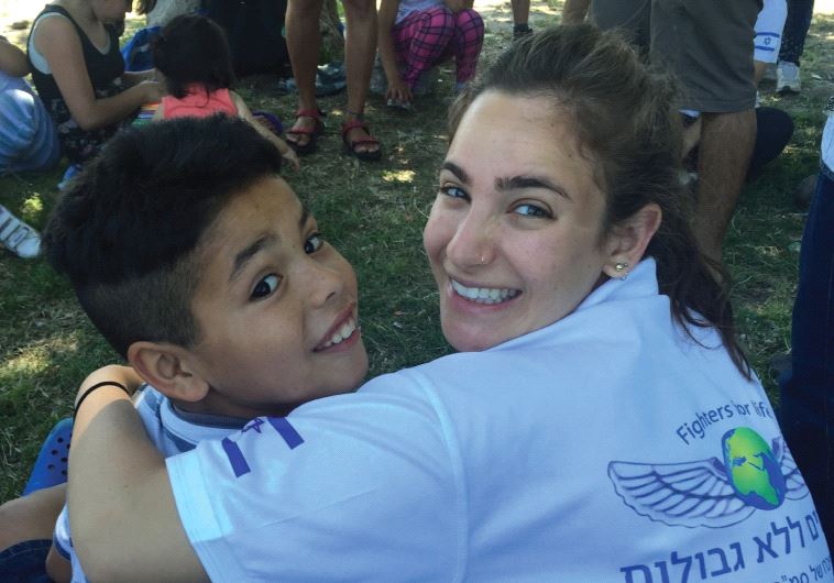 A FFL volunteer drapes her arm around a young Argentinian boy Source: Jerusalem Post
